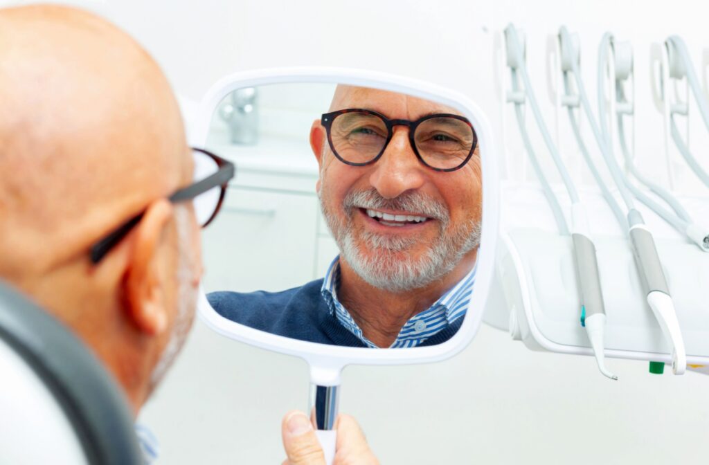 A person looking at their new dental implants while at the dentist